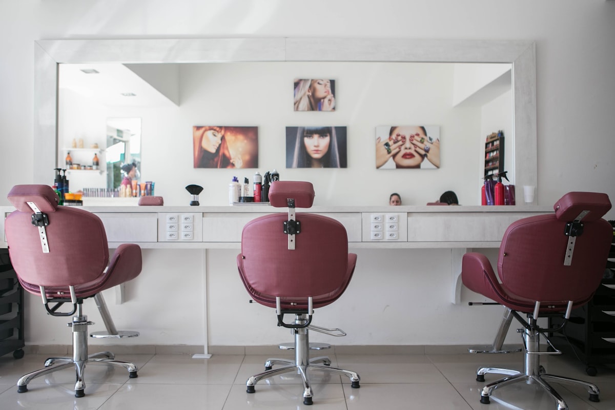 Salon chairs at a white vanity with large mirror